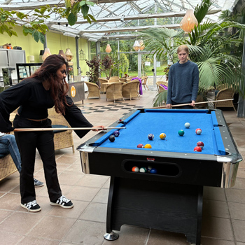 Två ungdomar spelar biljard