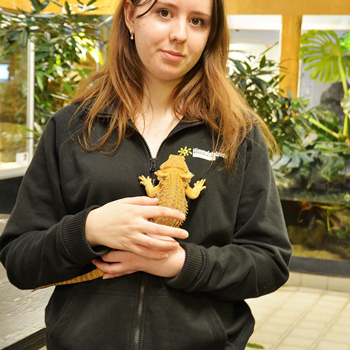 En ung kvinna med en ödla i famnen