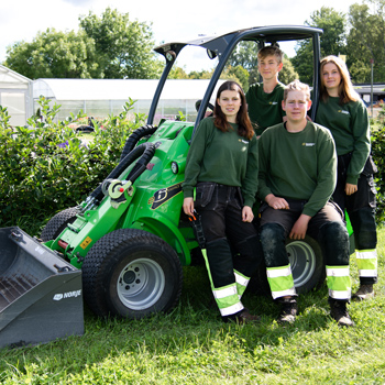 Fyra undomar och en grön minigrävare