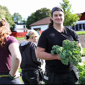 Ung man med grönsaker i famnen