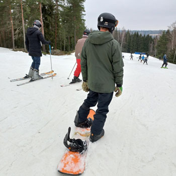 Ungdomar i en alpin backe