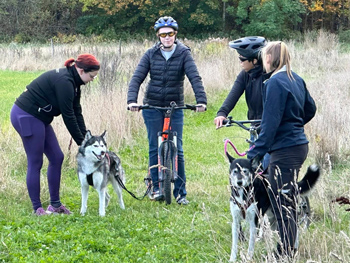 Flera personer med cyklar och hundar