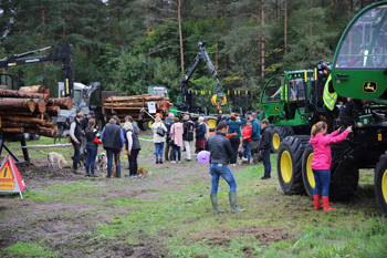 Många människor samlade kring skogsmaskiner i skogen